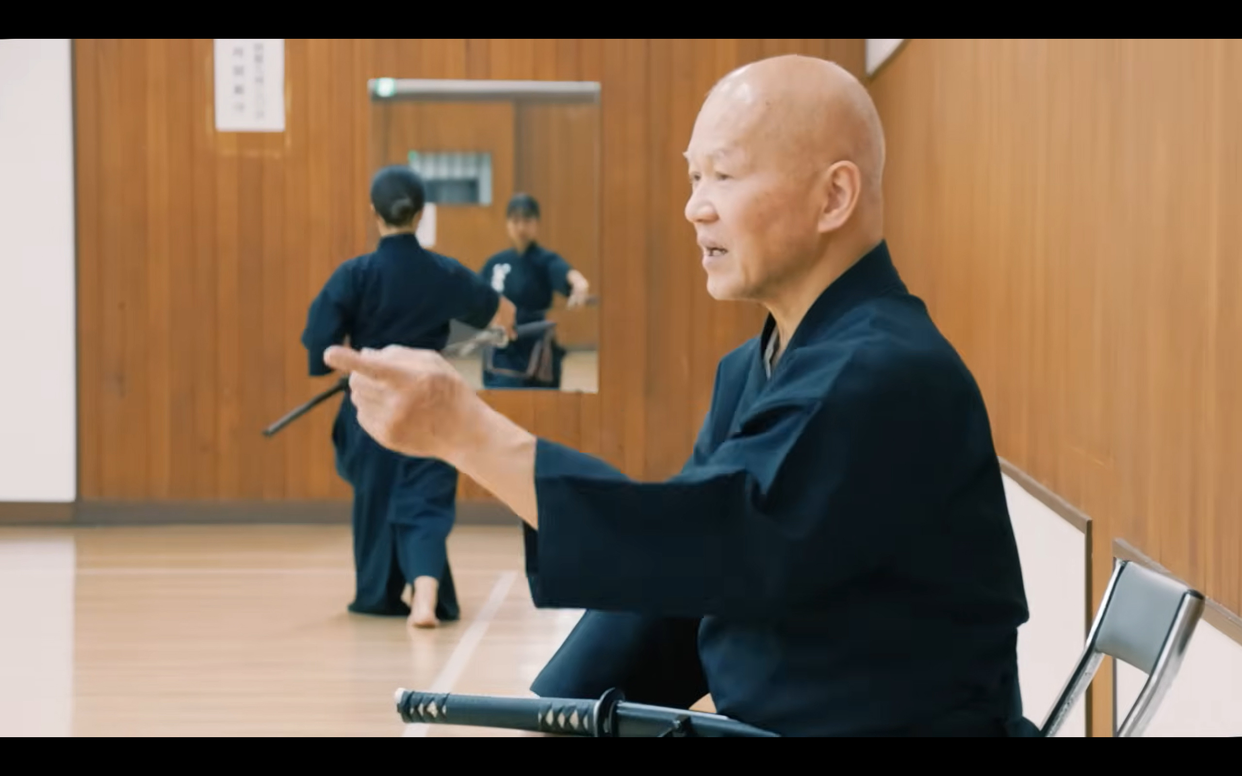 Instructor guiding sword practice in the dojo
